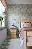 Bemalter Dielenboden und Blümchentapete im romantischen Schlafzimmer