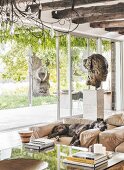 Dog on leather armchair and bust of woman in front of sliding terrace doors