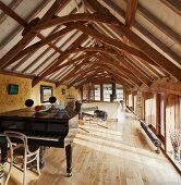 Helles Zimmer mit Klavierflügel in rustikalem Dachgeschoss mit restaurierter Fachwerkkonstuktion