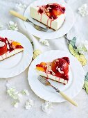 Three pieces of cheesecake with peaches and raspberry sauce