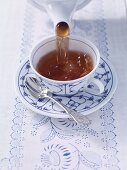 How to make East Friesian tea: pour the tea into the cup