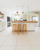 Bar stools at island counter in modern country-house kitchen