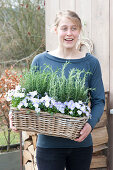 Woman bringing basket with Rosemary (Rosemary) and Viola