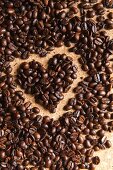 Coffee beans in the shape of a heart on a cork background
