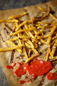 French fries on baking paper with ketchup