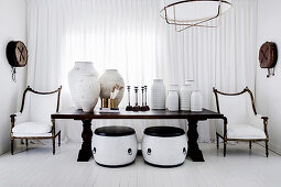 Holztisch mit Keramiksammlung und Tongefäßen, chinesische Trommeln als Beistelltische und Antik-Stühle vor Fenster