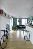 Fahrrad und Küchentheke im offenen Wohnraum mit Wohnzimmer