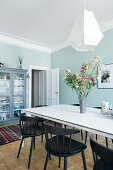 Dining room with pale blue walls in period apartment