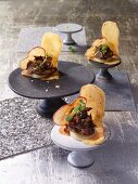 Duck canapes with dried apple slices on spicy wafer biscuits
