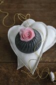 Silk flower and bundt tin on two fabric hearts