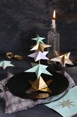 Arrangement of paper stars threaded on rod on plate