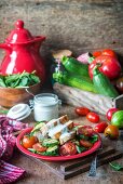 Salad with fried chicken, zucchini, tomatoes and yogurt dressing