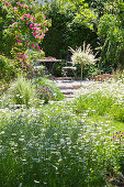 Blumenwiese im Sommergarten mit romantischem Sitzplatz