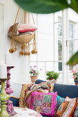 Colourful scatter cushions on sofa in conservatory