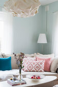 Scatter cushions on sofa and coffee table in corner of mint-green room