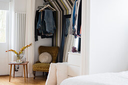 Walk-in wardrobe with striped wallpaper in bedroom