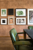 Green retro armchair at table in front of gallery on pictures on marbled wall
