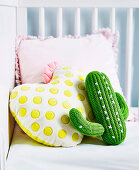 Gehäkelter Kaktus und Kissen mit gelben Punkten und rosa Rüschen