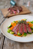 Flank steak in strips with carrot noodles and Brussels sprouts