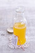 Woodruff and orange cordial in a small glass bottle with a cardboard tag