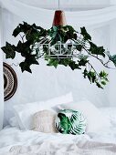 Lampshade decorated with artificial ivy over the bed
