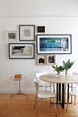 Round table, designer chairs and gallery of pictures on wall