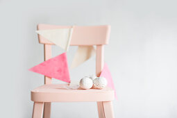 Bunting and speckled eggs on chair
