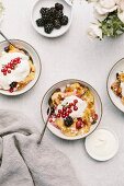 A goat's cheese and berry bread pudding, topped with crème fraîche and redcurrants