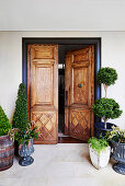 Entrance area with antique wooden door and box tree