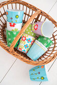 Colourful mugs in wicker basket