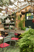 Garden tables and chairs in greenhouse of old nursery