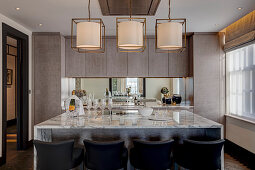 Kitchen island with marble worksurface and barstools