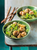 Sesame meatballs on noodles with green beans, chili and coriander