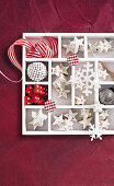 White chocolate stars with nuts and Christmas decorations in a box