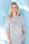 A young blonde woman wearing a light knitted jumper