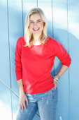 A young blonde woman wearing a red jumper