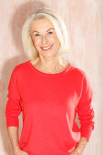 An older blonde woman wearing a red jumper