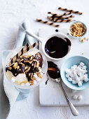 Vanilleeisbecher mit Mini Marshmallows, Mandeln und Schokoladensauce