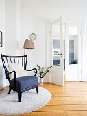 Old armchair on round rug in reading corner