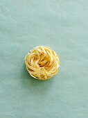 A tagliatelle nest on a textured background