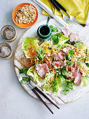 Salad with duck (Thai style) on wooden plate