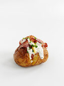 A baked potato with bacon and sour cream