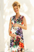 Schwangere Frau in ärmellosem Sommerkleid mit Blumenmuster