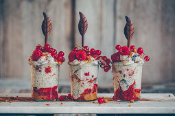 Ice cream in glasses with poppy seeds, gingerbread cream, berries and cinnamon with wooden spoons
