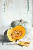 Two Crown Prince pumpkin against a white wooden background