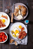 Fried eggs with bacon, tomatoes and poppy seed rolls