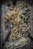 Fresh mustard pasta with kale and salsiccia on a wooden board
