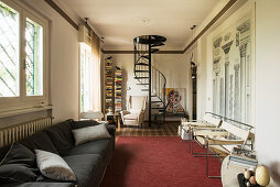 Spiral staircase and architectural diagram on wall in Italian-style living room