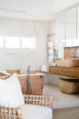 Designer chair, wood-clad bathtub and washstand in bright bathroom