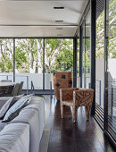 Sculptural chair in living room with glass walls